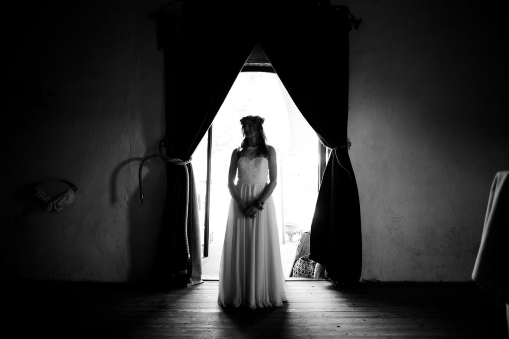lauraseelig_mühlenhof_Braut schwarzweiß bild einer braut, die in einer Tür steht