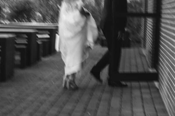 schwarz-weiß Bild des Hochzeitspaares, wie es aufs Zimmer geht im Absalonshorst